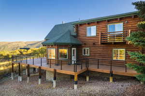 Back of house with a deck with mountain view