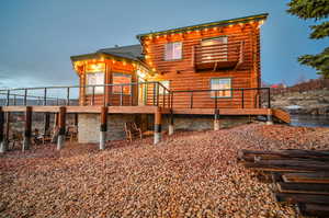 Back house at dusk featuring a wooden deck