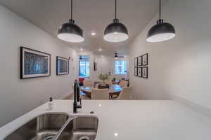 Kitchen featuring hardwood / wood-style floors, hanging light fixtures, ceiling fan, and sink