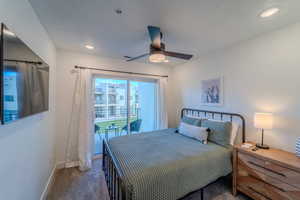 Carpeted bedroom featuring a textured ceiling, ceiling fan, and access to exterior