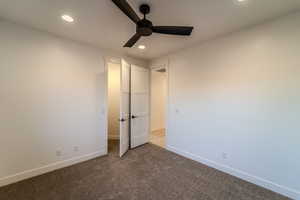 Unfurnished bedroom with ceiling fan and light carpet