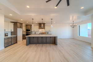 Kitchen featuring light wood-type flooring, appliances with stainless steel finishes, sink, and tasteful backsplash