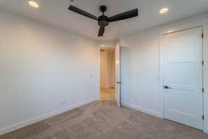 Unfurnished bedroom featuring ceiling fan and light carpet