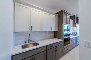 Kitchen with appliances with stainless steel finishes, white cabinets, and tasteful backsplash