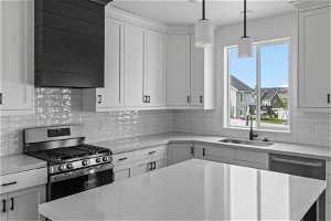 Kitchen with a healthy amount of sunlight, appliances with stainless steel finishes, white cabinets, and sink