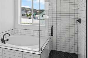 Bathroom featuring a relaxing tiled bath and tile floors