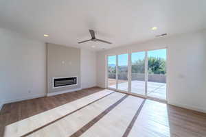 Unfurnished living room with light wood-type flooring and ceiling fan