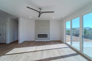 Unfurnished living room featuring hardwood / wood-style flooring and ceiling fan