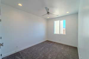 Unfurnished room featuring carpet flooring and ceiling fan