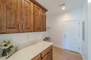 Kitchen with light hardwood / wood-style floors and electric panel