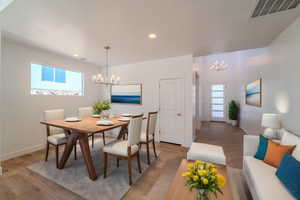 Dining space featuring hardwood / wood-style flooring, a healthy amount of sunlight, and an inviting chandelier