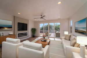 Living room with hardwood / wood-style flooring, a textured ceiling, and ceiling fan