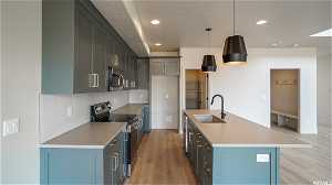 Kitchen featuring appliances with stainless steel finishes, sink, a center island with sink, and backsplash