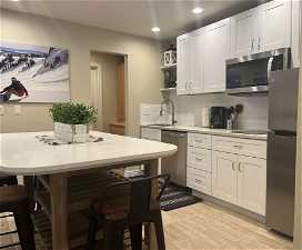 Kitchen with sink, light hardwood / wood-style floors, tasteful backsplash, and stainless steel appliances