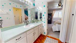 Bathroom featuring ceiling fan, parquet floors, and large vanity