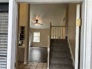 Stairs with ceiling fan and light tile floors
