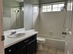 Full bathroom featuring tile flooring, oversized vanity, tiled shower / bath combo, and toilet