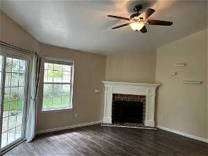 Family room with plenty of natural light, ceiling fan, and dark hardwood / wood-style floors