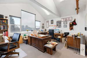 Office area with light carpet and lofted ceiling