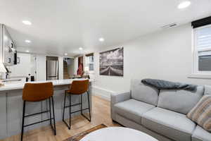 Living room with light hardwood / wood-style flooring and sink