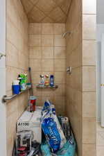 Bathroom with tiled shower and tile walls