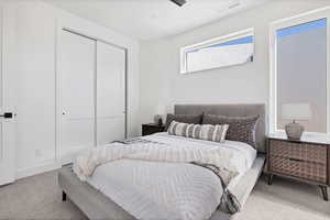 Bedroom featuring light carpet and a closet