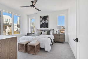 Bedroom with multiple windows, light carpet, and ceiling fan