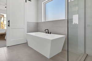 Bathroom with a bathtub and tile walls