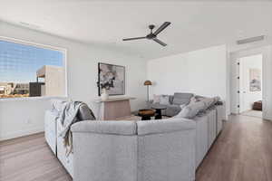 Living room with ceiling fan and light wood-type flooring