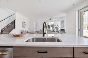 Kitchen featuring sink, ceiling fan, and a center island with sink