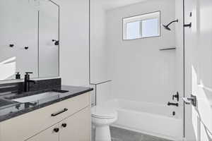 Full bathroom with vanity, toilet, and tiled shower / bath combo