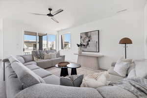 Living room with ceiling fan and light hardwood / wood-style flooring