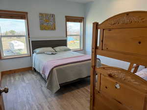 Bedroom with LVP hardwood / wood-style flooring