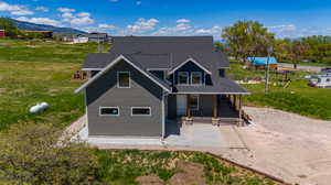 Rear view of property featuring a yard, a mountain view, and a patio