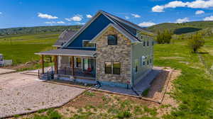 Back of property with covered porch and a rural view