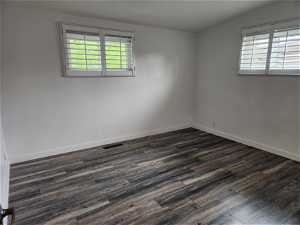 Spare room with dark hardwood / wood-style floors and lofted ceiling