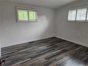 Spare room with vaulted ceiling and dark hardwood / wood-style flooring