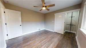 Unfurnished bedroom featuring a closet, dark hardwood / wood-style floors, and ceiling fan