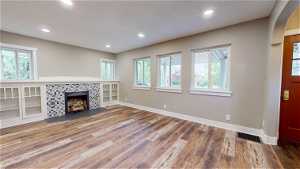 Unfurnished living room with a tile fireplace and hardwood / wood-style floors