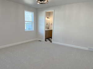 Interior space with ensuite bath and light carpet