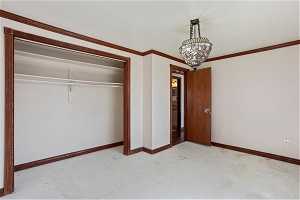 Unfurnished bedroom with ornamental molding and a closet