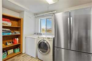 Laundry room featuring light hardwood / wood-style flooring and washer and clothes dryer