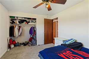 Bedroom featuring a closet, ceiling fan, and carpet flooring
