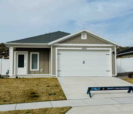 View of front of property featuring fence, a shingled roof, an attached garage, and concrete driveway