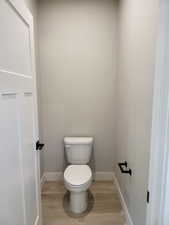 Bathroom featuring toilet and wood-type flooring