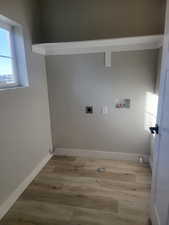 Washroom with washer hookup, electric dryer hookup, and light hardwood / wood-style floors