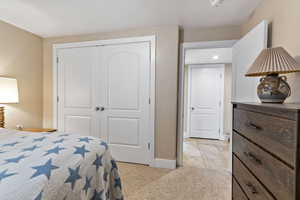 Carpeted bedroom with a closet