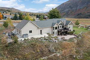 Back of house featuring a deck with mountain view and a patio