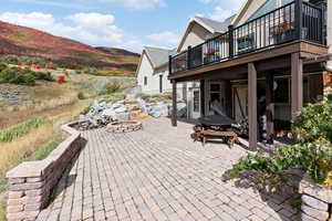 View of patio featuring a balcony, a mountain view, and an outdoor fire pit