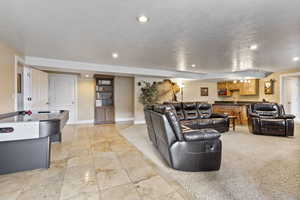 Living room with light tile flooring and light colored carpet